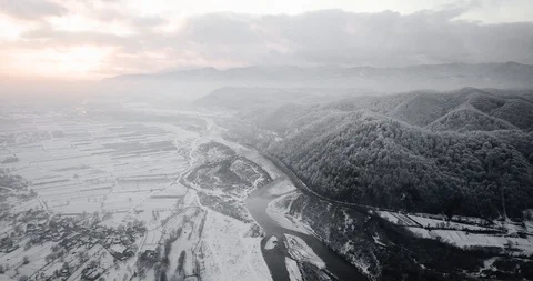 Snow-capped mountains river sunset snowfall drone Stock Footage 122602552