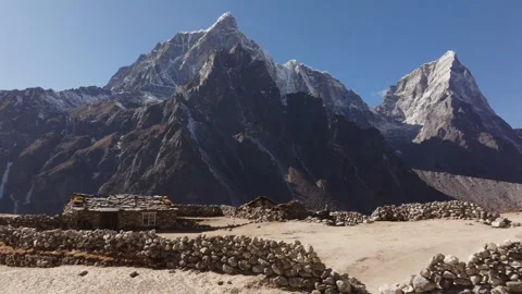 Snow-capped mountains with rustic stone house Stock Footage 330179088