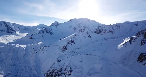 Snow-capped mountains. Shooting with the drone. White snow on gray. Stock Footage 100705713