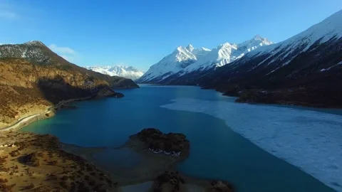 Snow capped mountains surround a pristine blue lake landscape Video stock 311819127