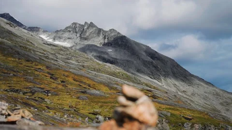Snow-capped mountains tower above the valley. Stone cairns in the Stock Footage 270283264