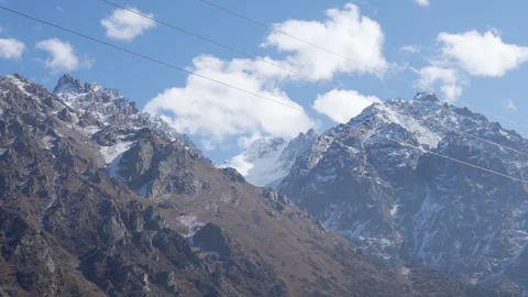 Snow-capped mountains under a clear blue sky. The rugged terrain features rocky Stock Footage 310218308