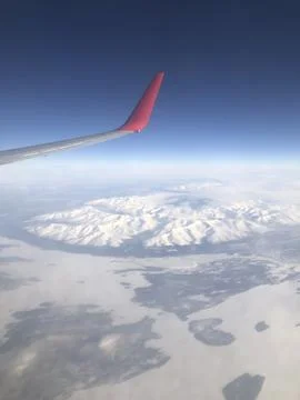 Snow-capped mountains under the wing Stock Photos