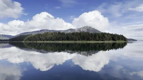 Snow-Capped Peak and Forested Point Mirrored Cleanly in Bright Still Water Stock Footage 336220439