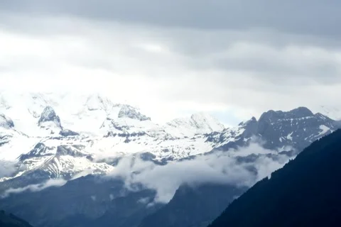 Snow-Capped Peaks and Clouds in a Mountainous Landscape Stockbeeldmateriaal 348156710