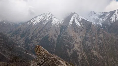 Snow-capped peaks tower over Kyrgyzstan's rugged Pamir landscape Stockfoto's