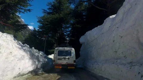 Snow-capped road at ice mountain route and pine tree forest Stock Footage 220698385