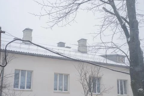 Snow-capped roofs of multi-storey houses with wires Foto stock