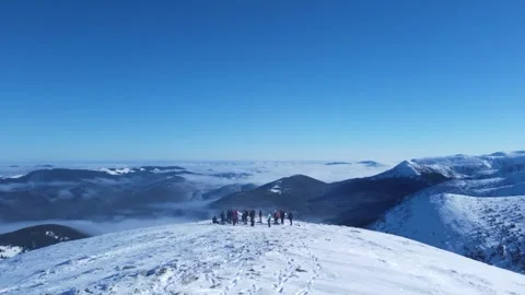Snow-capped tops of mountains over which clouds are visible on a sunny day. Stock Footage 302541036
