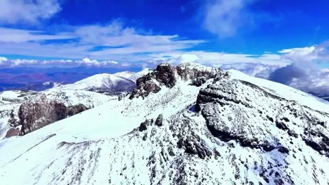 Snow-Capped Volcanic Mountain Under Bright Sky Stock Footage 310856613