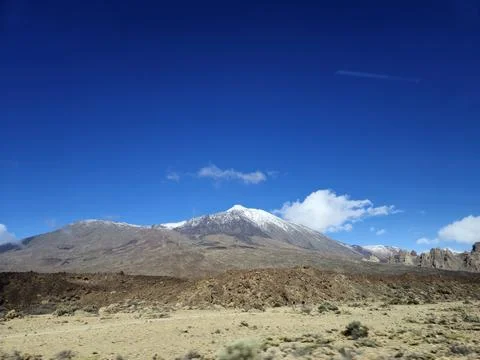 Snow capped volcanic mountain under clear blue sky Stock Photos