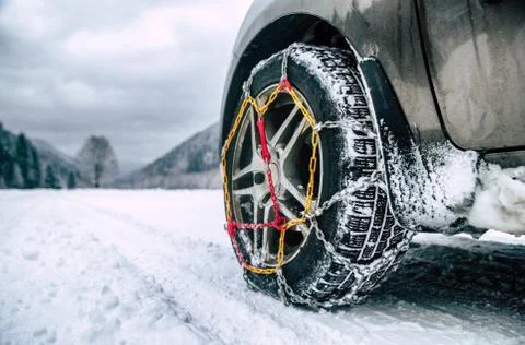 Snow chains on tire at winter road Stock Photos