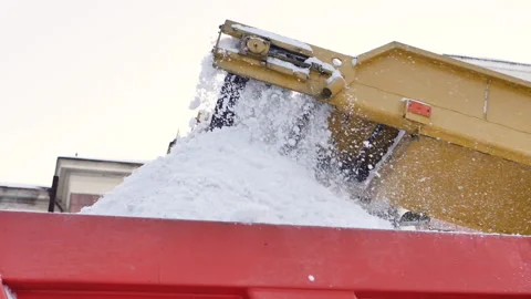 Snow cleaning tractor, claw loader vehicle loading pile of snow on a dump truck. Stock Footage 169797892
