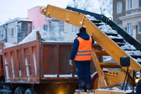 Snow cleaning tractor loading pile of snow on a dump truck. Isolate. Snow plow Stock Photos
