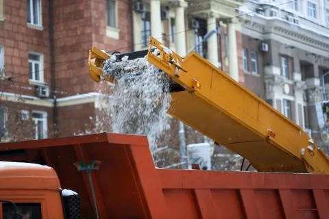 Snow cleaning tractor loading pile of snow on a dump truck. Isolate. Snow plow Stock Photos