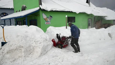 Snow clearing - man struggles with snow blower in heavy snow Stock Footage 169903082