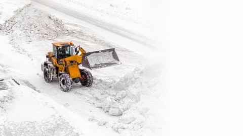 Snow clearing. Tractor clears the way after heavy snowfall. Stock Photos