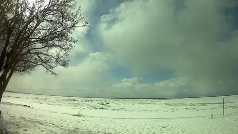 Snow, clouds, a lonely tree, snowman and a frozen sea Video stock 74580603