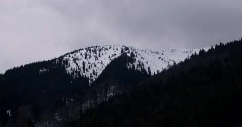Snow Clouds Moving Across a Snowy Mountain Stock Footage 61873480