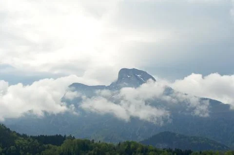Snow clouds swirling around a mountain. Stock Photos