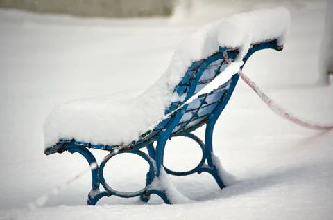 Snow coevered bench in winter Stock Photos