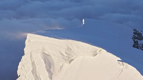 Snow cornice avalanche breaking on mountain peak Stock Footage 337022722
