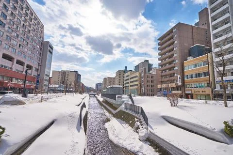 A snow covered along of Sosei river through Sapporo city in Hokkaido, Japan. Stock Photos
