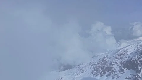 Snow-covered alpine ridge in Nauders, Austria, partly veiled by drifting cloud Stock Footage 333320293