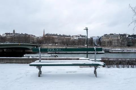Snow-covered bench facing the Seine river in Paris, France. 写真素材