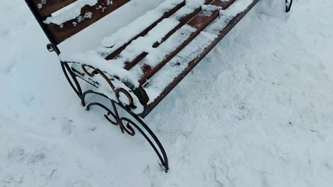 Snow-covered bench in the park in winter. Winter weather and snowing. Copy space Video stock 295605049