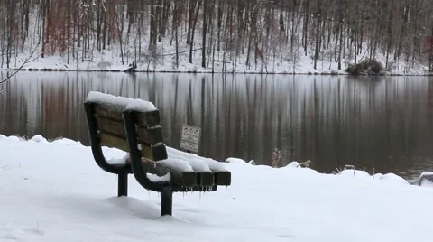Snow Covered Bench by Water Stock Footage 58906372