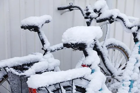 Snow-covered bikes next to each other Stock Photos