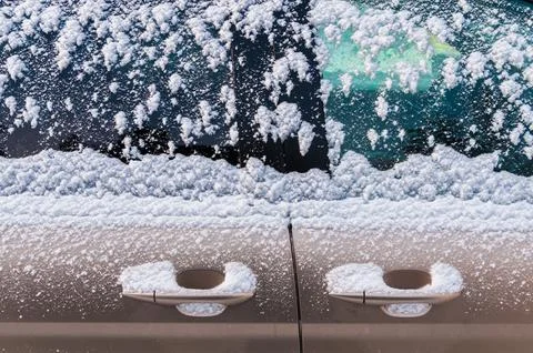 Snow covered car door handles and windows Stock Photos