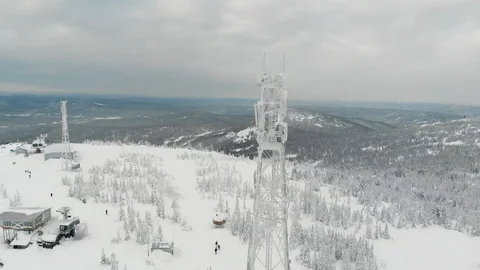Snow covered cell tower on the mountain. aerial video Stock Footage 98986389