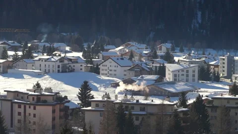 Snow-covered chalets and hotels on the edge of Davos Stock Footage 345299343