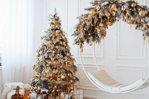 Snow-covered Christmas Tree with Golden Toys and Garland. Round Swing Decorat Stock Photos