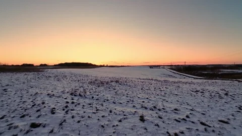 Snow-covered construction site during sunrise captured from drone flying forward Stockbeeldmateriaal 319506433