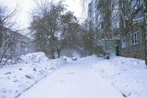 Snow-covered courtyard of a multi-storey building, large snowdrifts Stock Photos