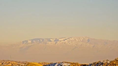 Snow-Covered Danxia Peaks with Distant Mountains Sunset B-Roll Stock Footage 325866824