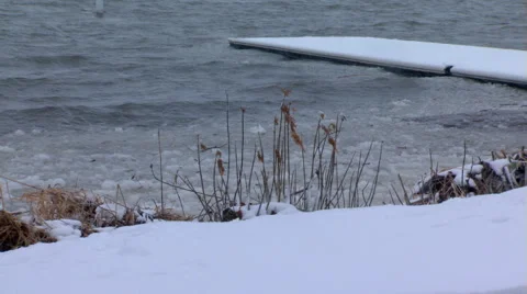 Snow-covered dock beside an icy lake Stock Footage