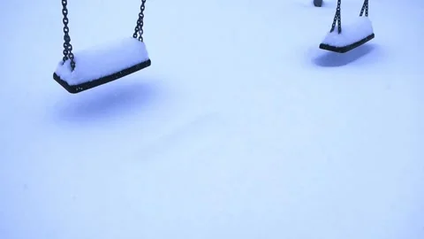 Snow Covered Empty Swings Swinging at a Deserted Playground in Winter Stock Footage 333432468