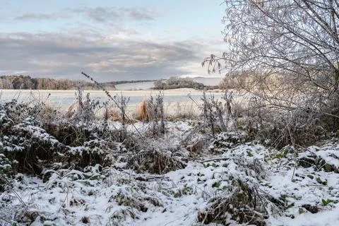 Snow covered fields and trees with snow on the distant hills in the Scotland Stock Photos
