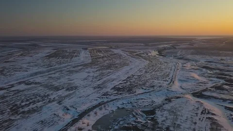 Snow-covered fields at sunset from a bird's eye view Stock Footage 123101522