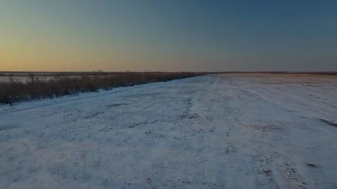 Snow-covered fields at sunset from a bird's eye view Stock Footage 123101646