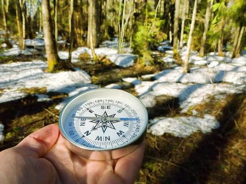 Snow-covered forest, compass in hand Fotos Stock
