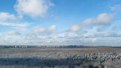 Snow-covered forest stretching toward distant urban skyline, time lapse. A .. Stock Photos