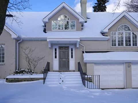 Snow covered front steps of painted brick house with gables Stock Photos