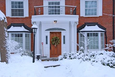 Snow covered front yard of brick house Stock Photos