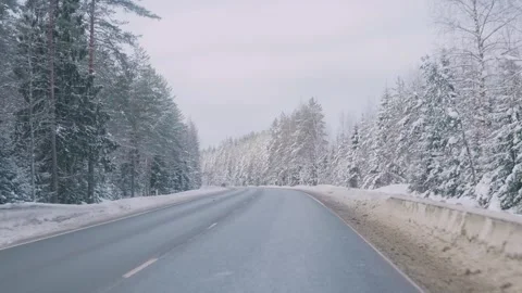 A snow-covered highway in winter in the middle of the forest Stock Footage 331501963