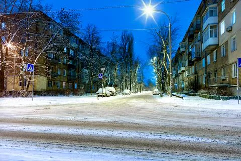 Snow-covered intersection on the road along a city street with trees in the s Stock Photos